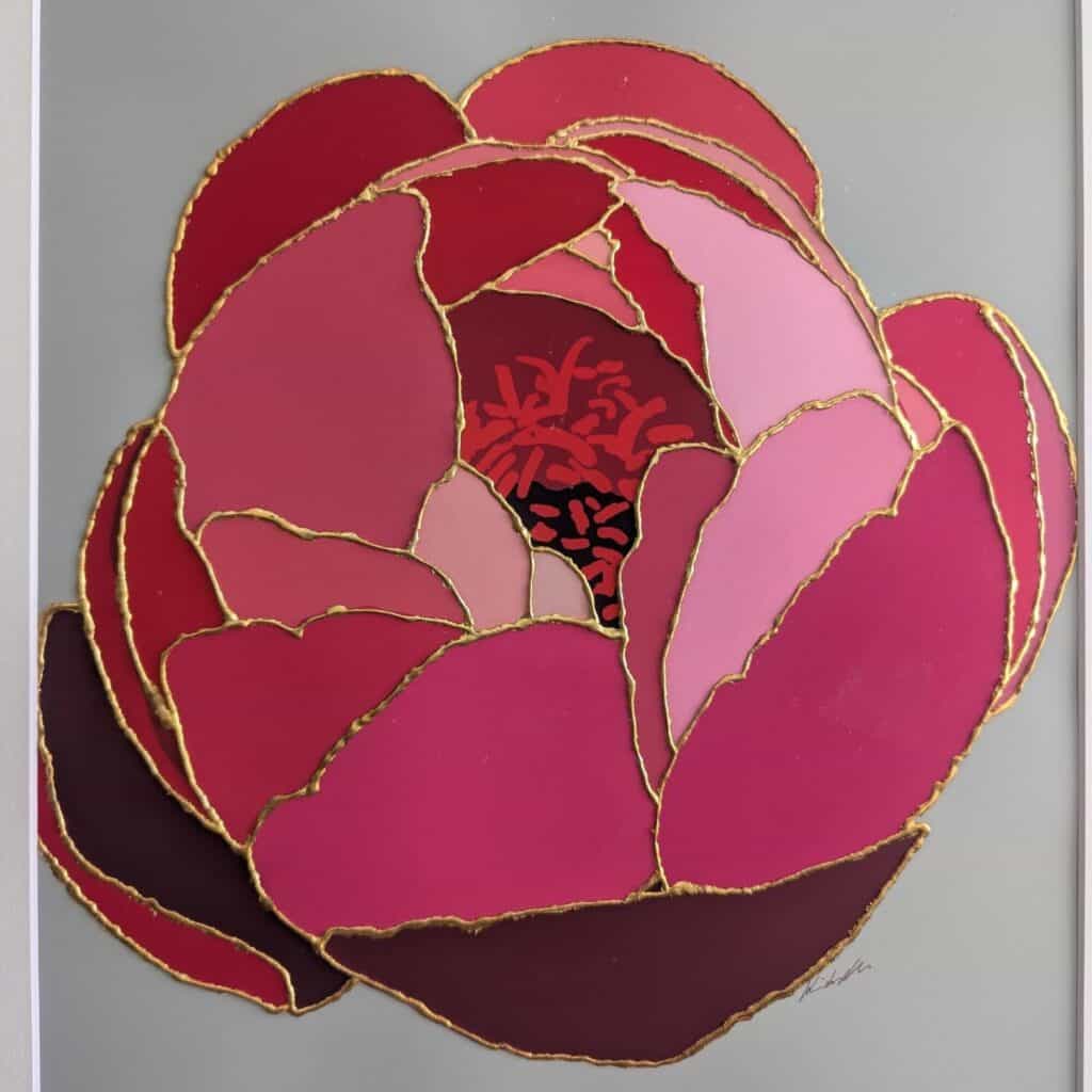 A stylized pink and red flower with gold-outlined petals is displayed against a plain gray background.
