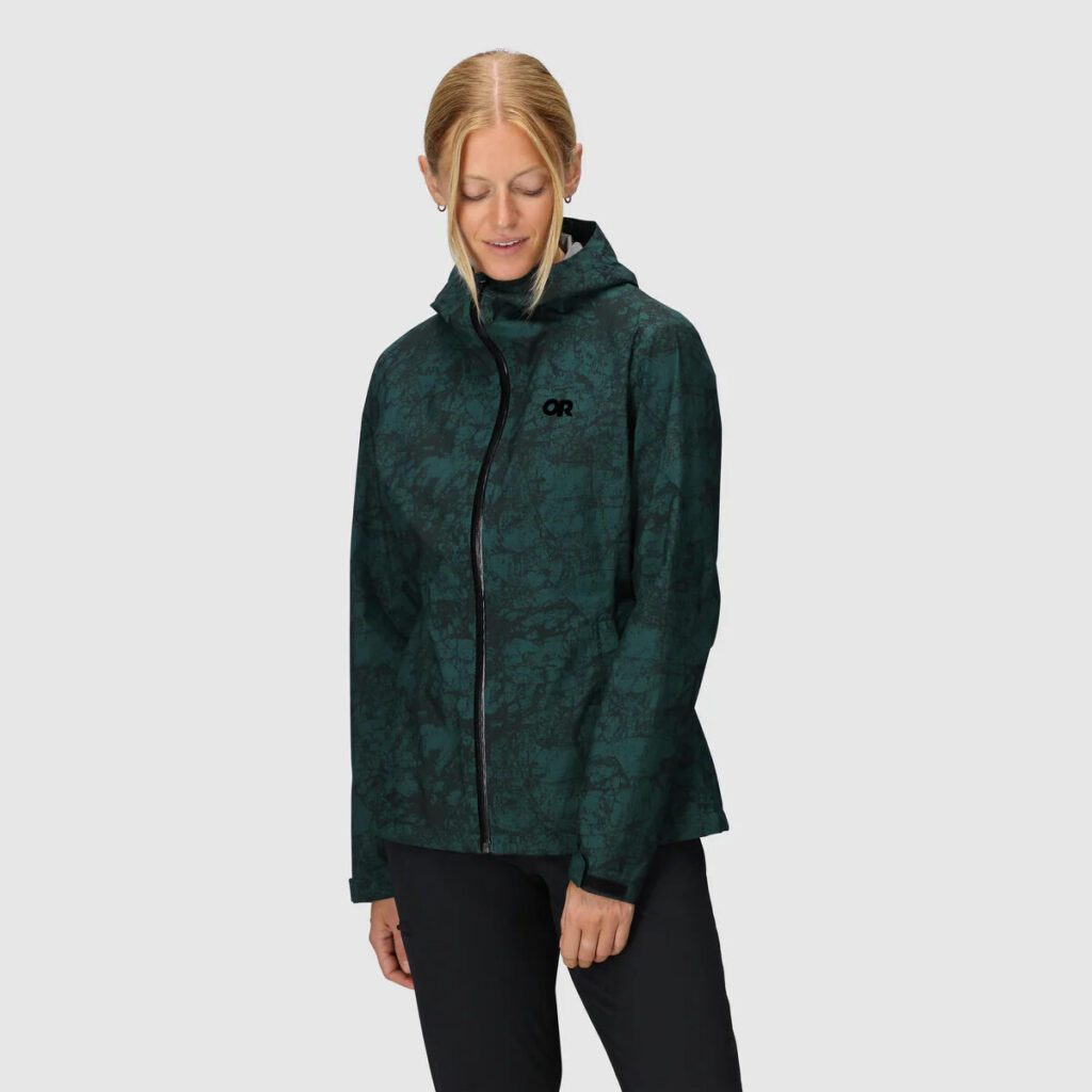 A person wearing a dark green, patterned hooded jacket with a front zipper, standing against a plain light gray background—perfect inspiration for Seattle style or unique Mother’s Day gifts.