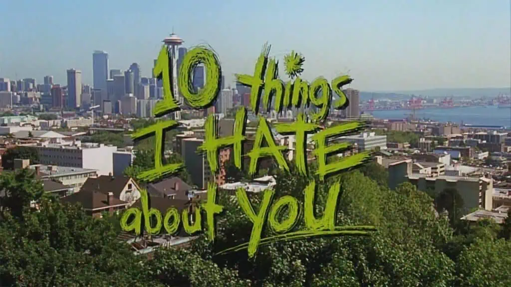 Title "10 Things I Hate About You Turns 25" superimposed in green graffiti style over a panoramic view of Seattle, featuring the Space Needle on the left.